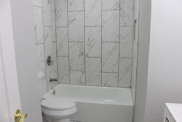 full bathroom with tiled shower / bath, vanity, and toilet