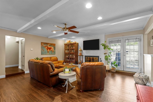 living room featuring a fireplace, beam ceiling, ceiling fan, and dark wood-type flooring