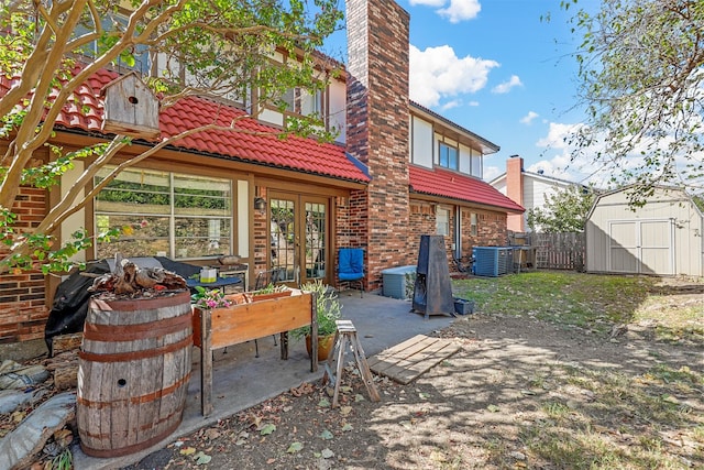 rear view of house featuring a patio area, cooling unit, and a storage unit