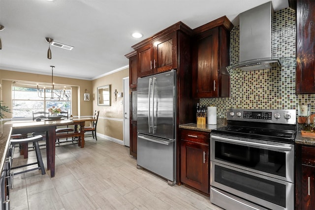 kitchen featuring dark stone countertops, wall chimney exhaust hood, stainless steel appliances, and ornamental molding