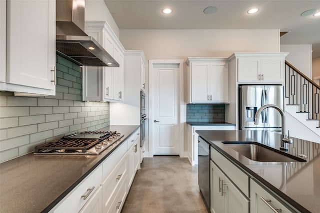 kitchen with white cabinetry, wall chimney range hood, sink, and appliances with stainless steel finishes