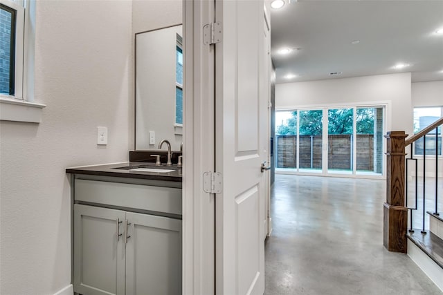 bathroom featuring vanity, a healthy amount of sunlight, and concrete floors