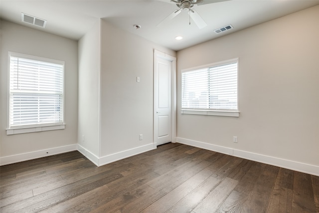 unfurnished room with a wealth of natural light, ceiling fan, and dark hardwood / wood-style floors