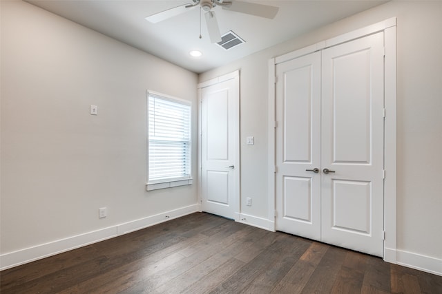 unfurnished bedroom with a closet, dark hardwood / wood-style floors, and ceiling fan