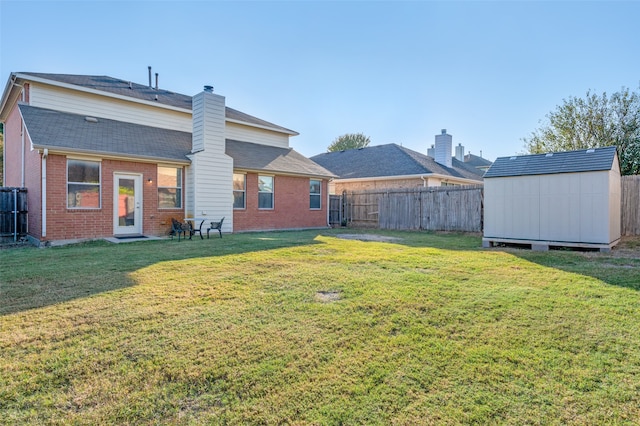 rear view of house with a shed and a lawn