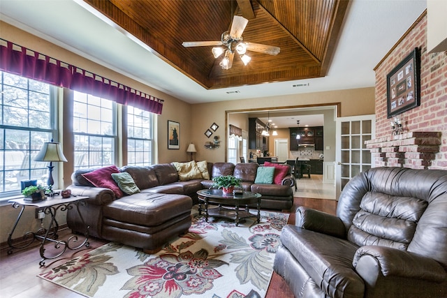 living room featuring hardwood / wood-style flooring, a tray ceiling, and wooden ceiling