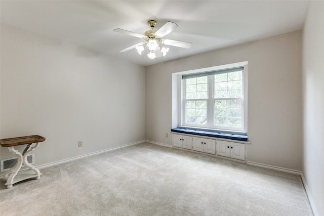 spare room featuring light carpet and ceiling fan