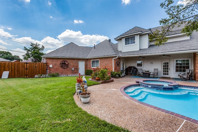 view of pool with a patio, ceiling fan, an in ground hot tub, and a yard