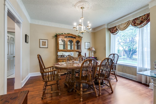 dining area featuring crown molding, wood-type flooring, a textured ceiling, and a chandelier