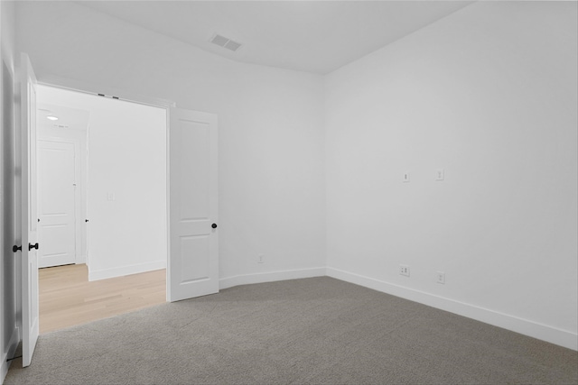 carpeted spare room with baseboards and visible vents