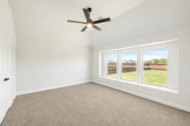 empty room featuring carpet flooring, ceiling fan, baseboards, and lofted ceiling