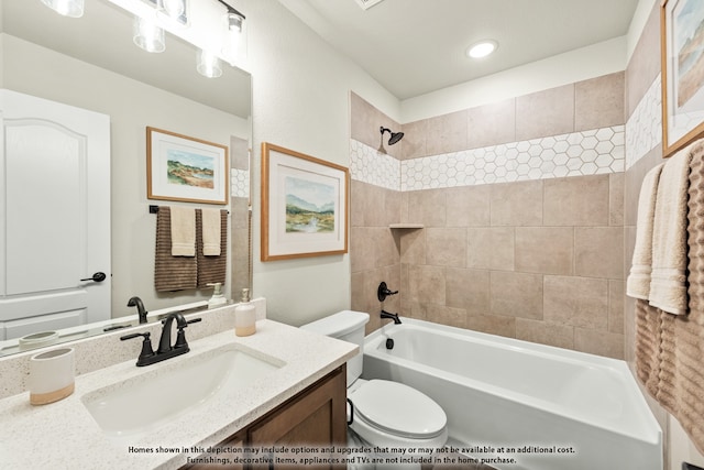 full bathroom featuring toilet, tiled shower / bath, and vanity