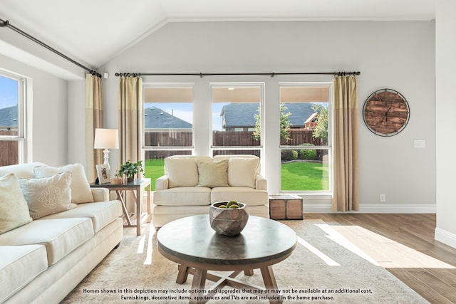 living room with lofted ceiling, light hardwood / wood-style floors, and plenty of natural light