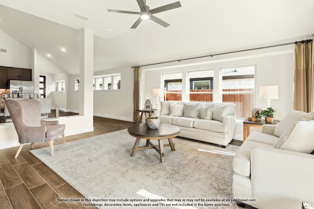 living room with dark wood-type flooring, ceiling fan, and high vaulted ceiling