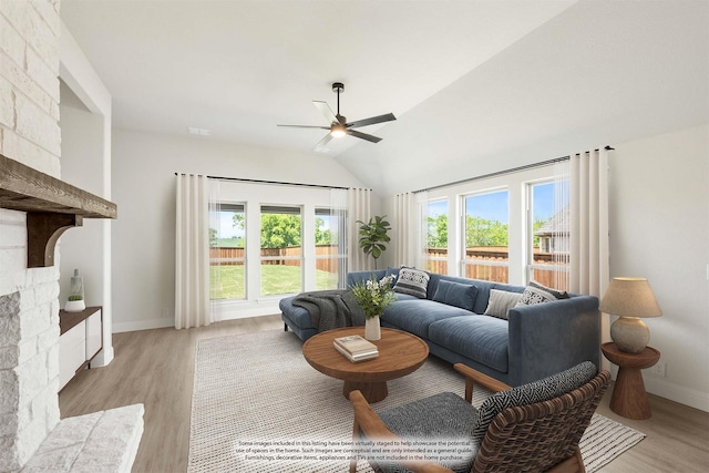 living room featuring ceiling fan, baseboards, lofted ceiling, and light wood-type flooring