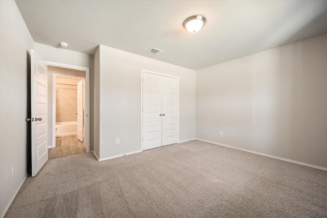 unfurnished bedroom featuring a closet, carpet, and a textured ceiling