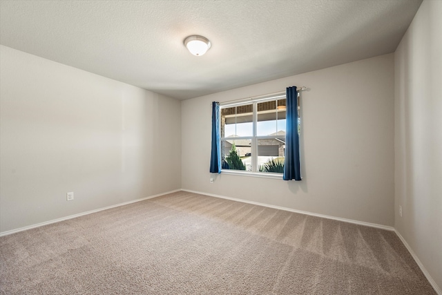 unfurnished room featuring carpet flooring and a textured ceiling