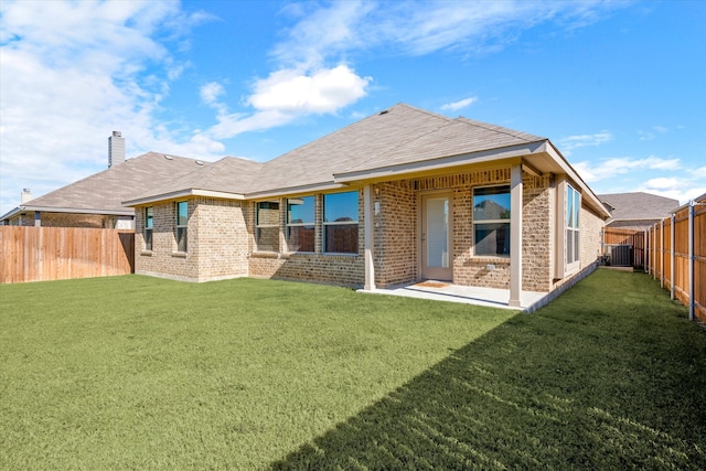 rear view of property featuring a lawn and central AC