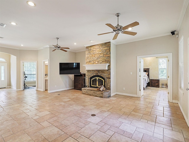 unfurnished living room with a stone fireplace, ceiling fan, and crown molding