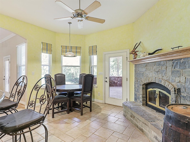 dining room featuring ceiling fan, ornamental molding, and a fireplace