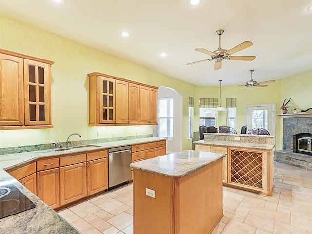 kitchen with stainless steel dishwasher, black electric cooktop, sink, pendant lighting, and a kitchen island