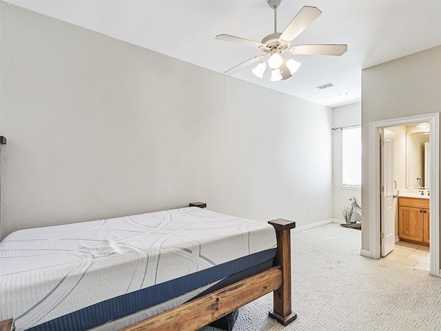 bedroom featuring ensuite bath, ceiling fan, and light colored carpet