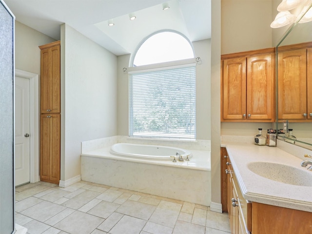 bathroom with a washtub, vanity, and tile patterned floors