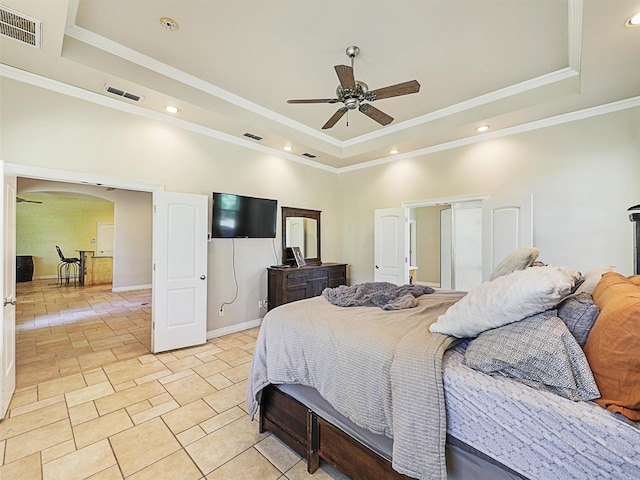 bedroom with ceiling fan, a raised ceiling, and crown molding