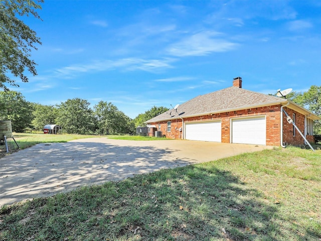 view of side of property with a yard and a garage