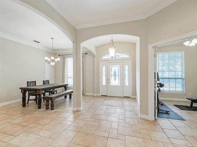 entrance foyer with ornamental molding and an inviting chandelier