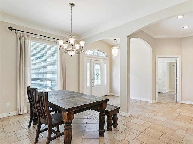 dining area with crown molding and a chandelier