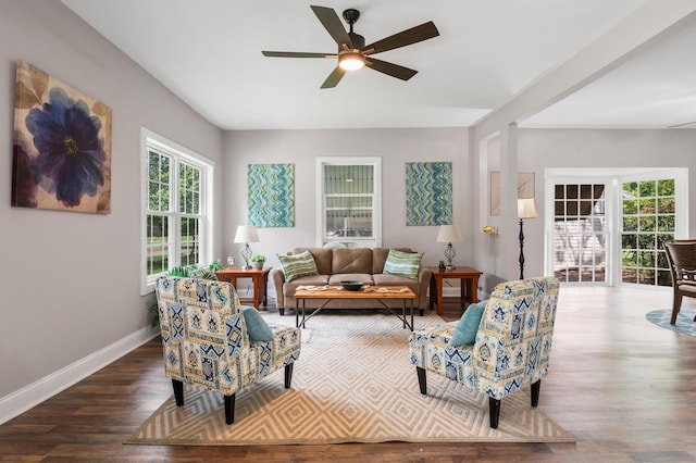 living room featuring wood finished floors, a ceiling fan, and baseboards