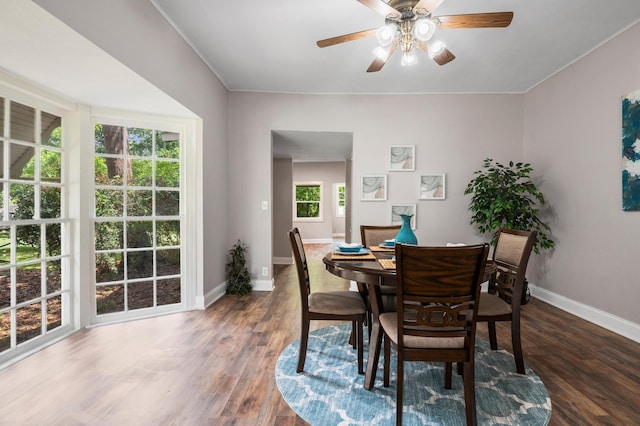 dining space featuring wood finished floors, a ceiling fan, and baseboards