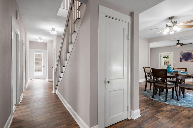hallway with baseboards, stairway, and dark wood-type flooring
