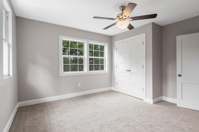unfurnished bedroom featuring ceiling fan, a closet, baseboards, and carpet floors