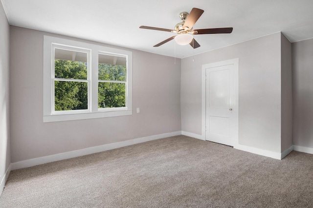 empty room featuring ceiling fan, carpet flooring, and baseboards