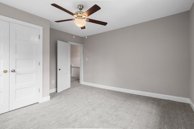 unfurnished bedroom featuring ceiling fan, a closet, and light carpet