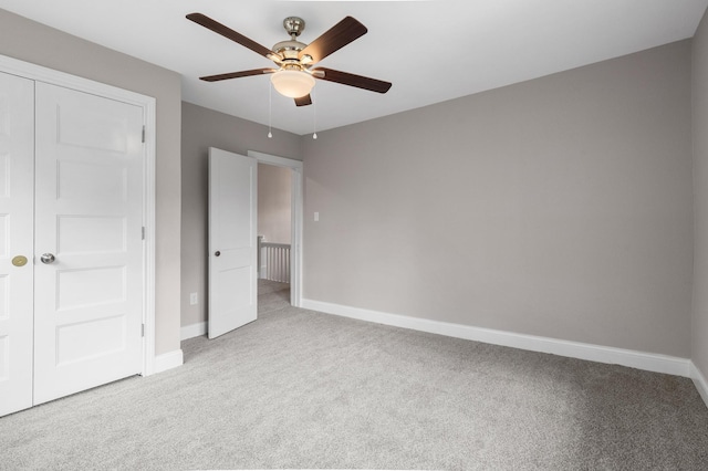 unfurnished bedroom featuring baseboards, ceiling fan, carpet floors, and a closet