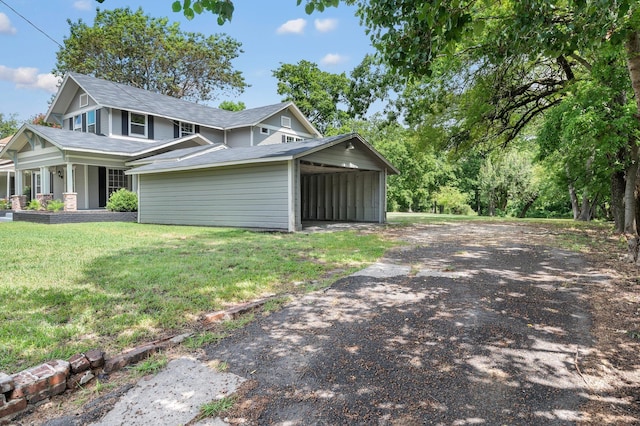 view of property exterior with a carport, a yard, a shingled roof, and aphalt driveway