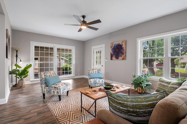 living room featuring dark wood-style flooring, ceiling fan, and baseboards