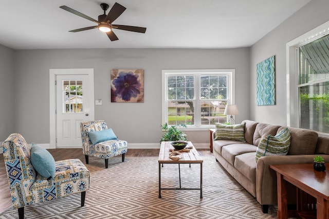 living room with baseboards, wood finished floors, and a ceiling fan