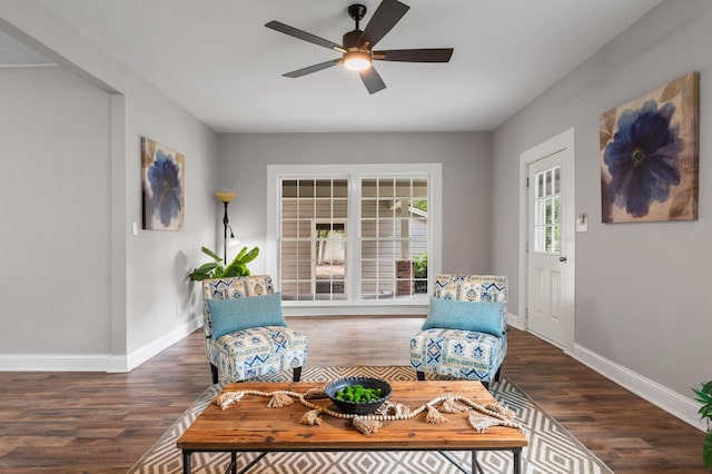 living area with ceiling fan, wood finished floors, and baseboards