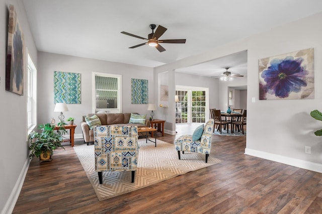 living room featuring ceiling fan and dark hardwood / wood-style flooring