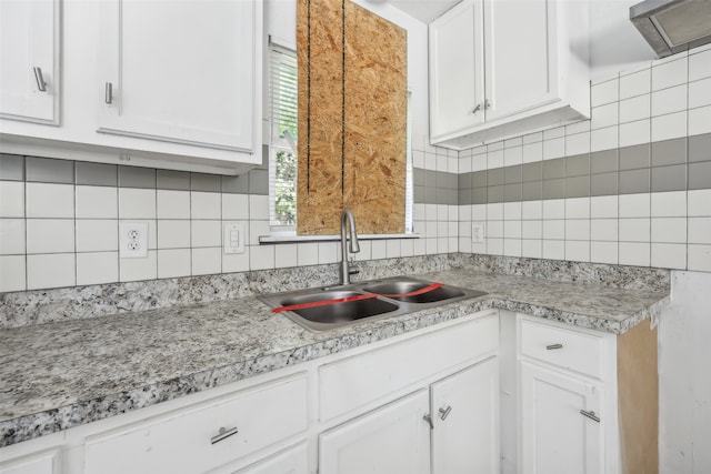 kitchen featuring extractor fan, white cabinetry, sink, and backsplash