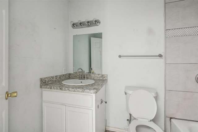 bathroom with vanity, toilet, and a bath