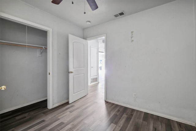 unfurnished bedroom with a closet, dark hardwood / wood-style floors, and ceiling fan