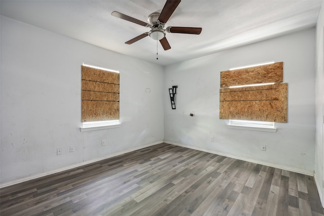 spare room with dark wood-type flooring and ceiling fan