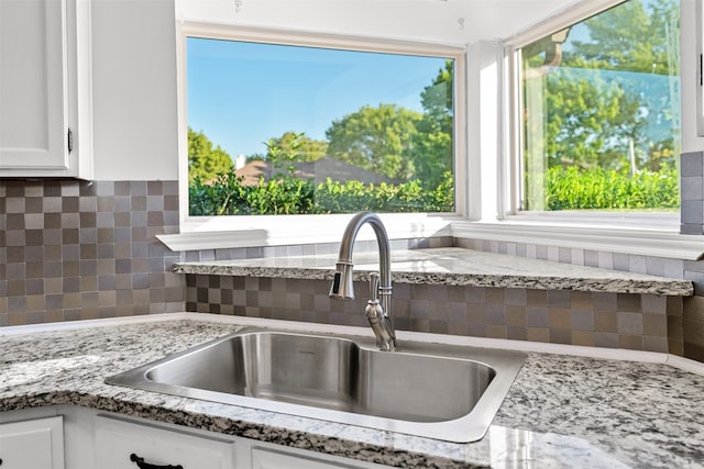 kitchen with sink, white cabinetry, and decorative backsplash