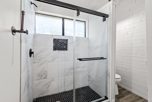 bathroom featuring hardwood / wood-style flooring, toilet, and an enclosed shower