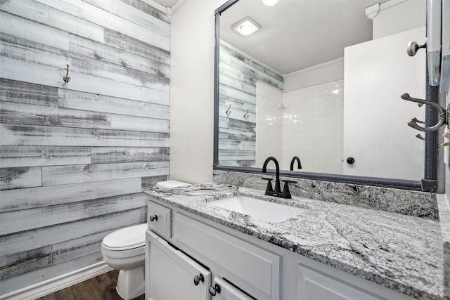 bathroom with vanity, toilet, wood walls, and hardwood / wood-style floors